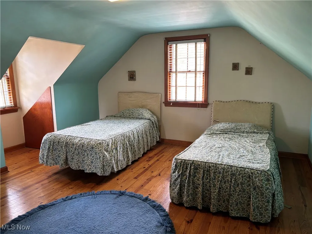 Bedroom with lofted ceiling and hardwood / wood-style floors