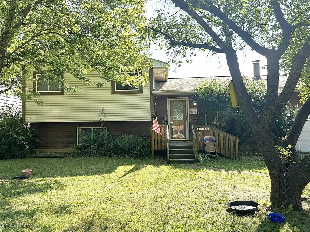 View of front of house featuring a front lawn and a shingled roof