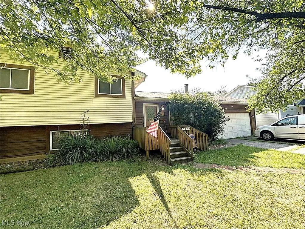 View of front of home with a front yard and an attached garage