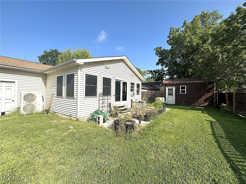 Back of house with a storage shed