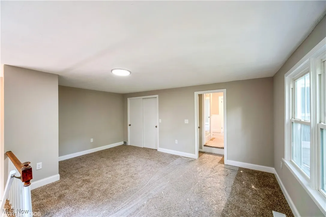 Unfurnished bedroom featuring carpet, a closet, and connected bathroom