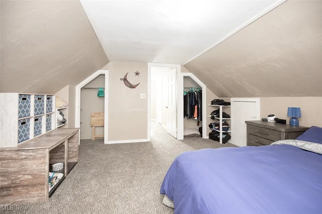 Carpeted bedroom with lofted ceiling and a closet