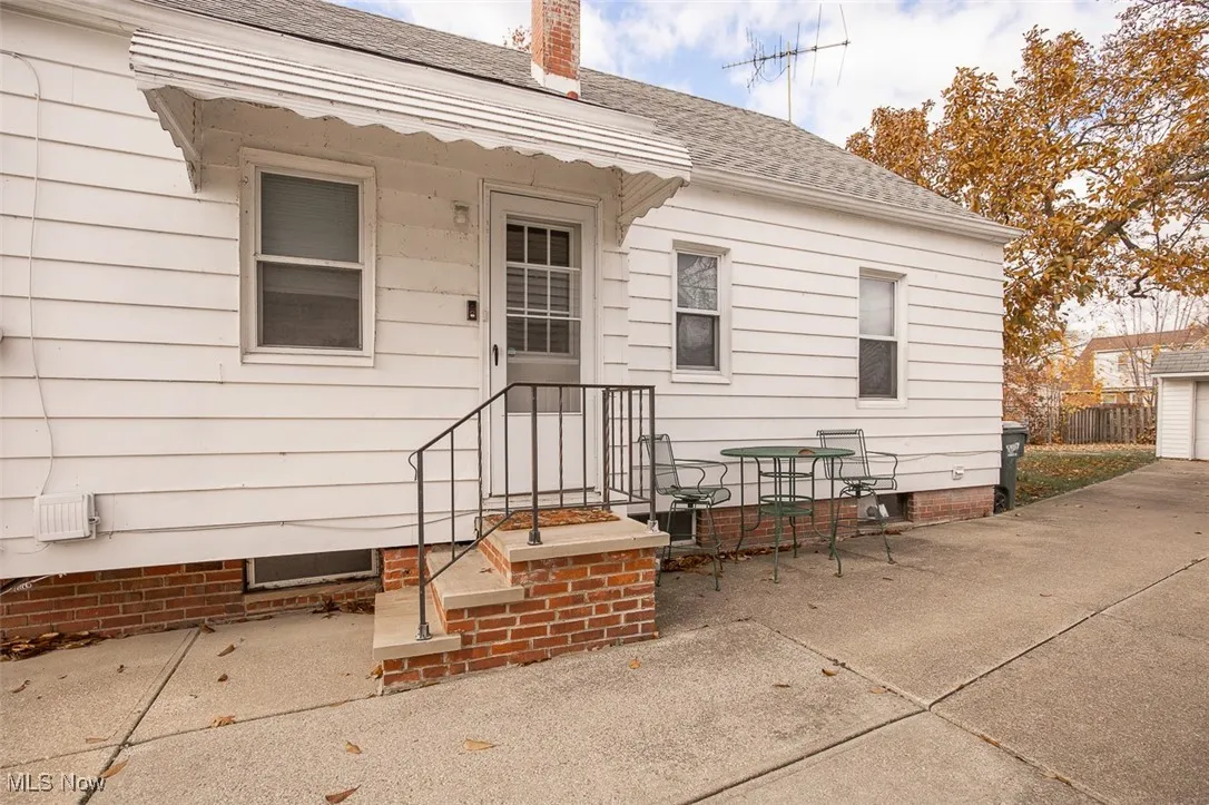 Property entrance with a shingled roof and a chimney