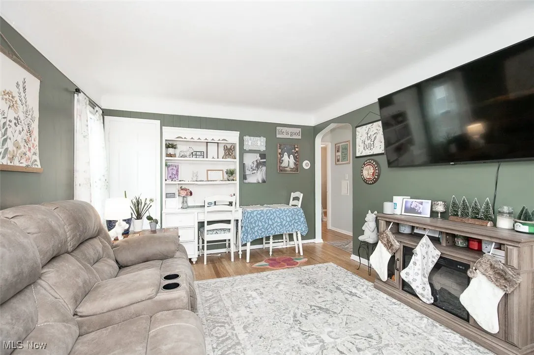 Living room featuring arched walkways and wood finished floors