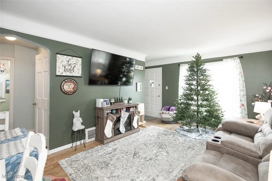 Living area with wood finished floors and arched walkways