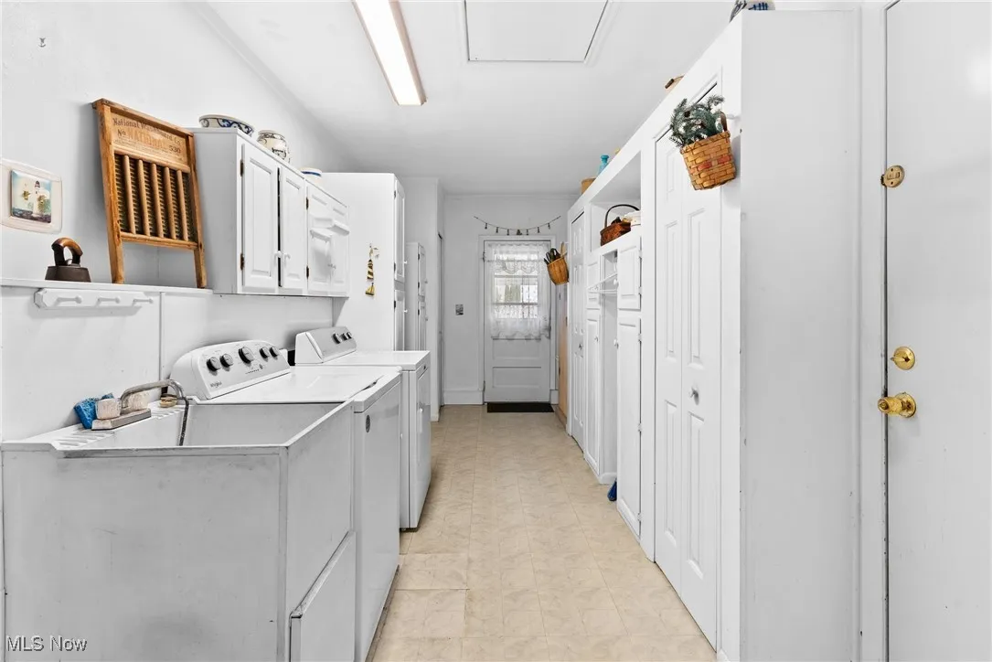 Laundry area featuring independent washer and dryer and cabinet space