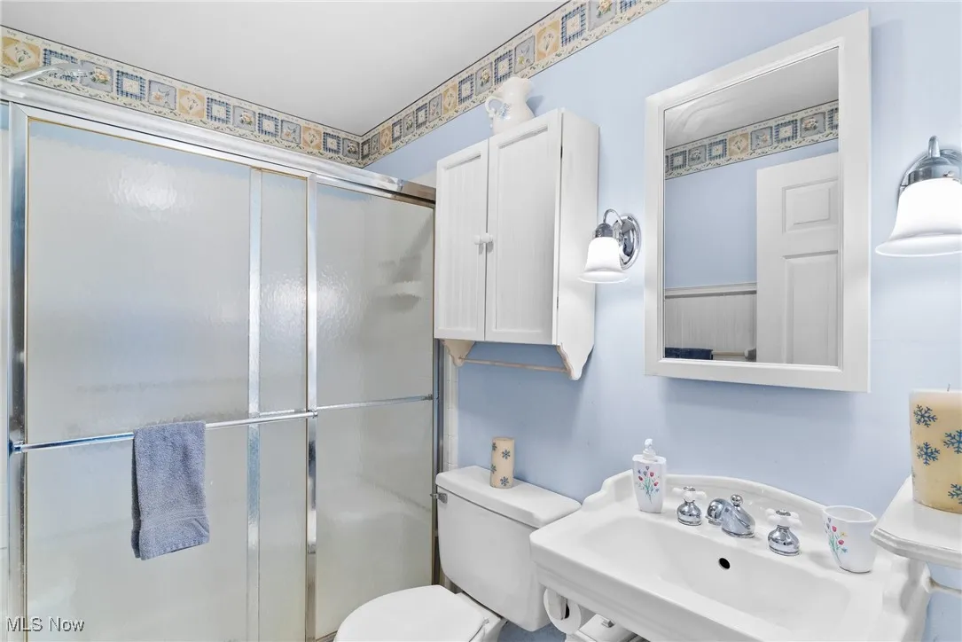 Full bathroom featuring a stall shower and toilet