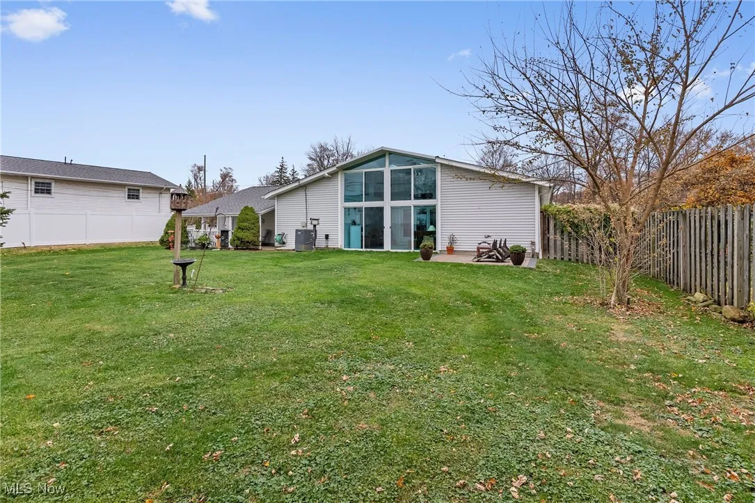 Rear view of house with a fenced backyard and a patio area