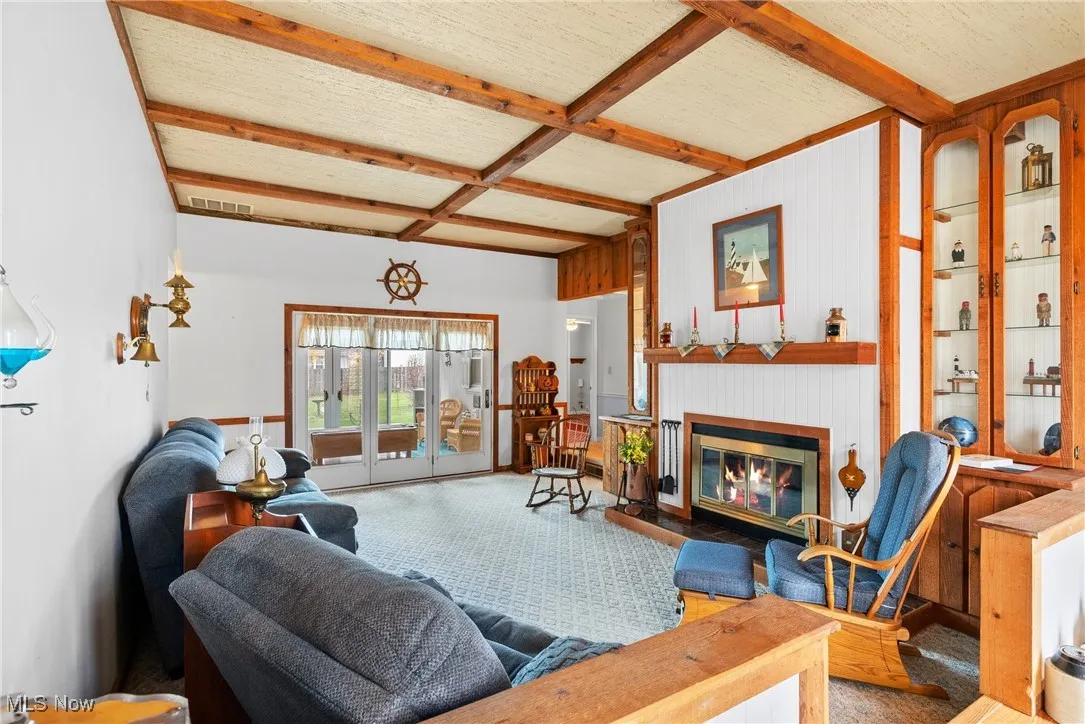 Living area with beamed ceiling, a fireplace with flush hearth, and coffered ceiling
