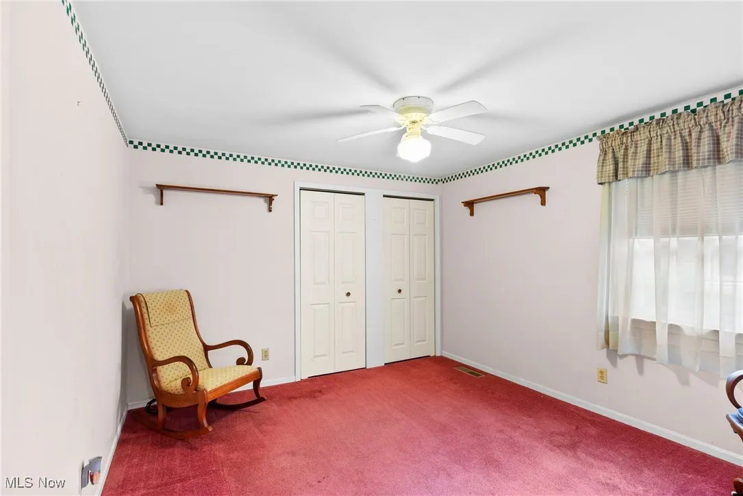 Living area featuring carpet flooring and ceiling fan