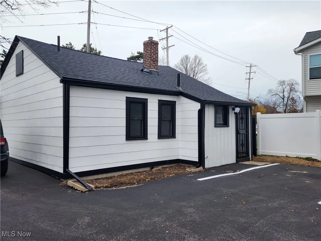 View of property exterior with roof with shingles and a chimney