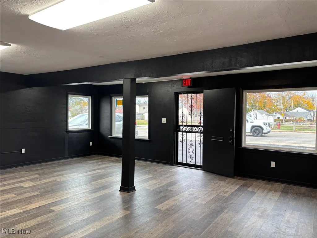 Open room featuring a textured ceiling and wood finished floors