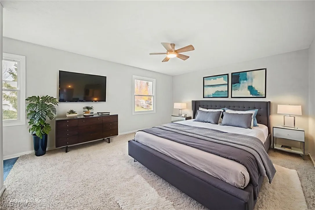 Carpeted bedroom featuring ceiling fan and baseboards