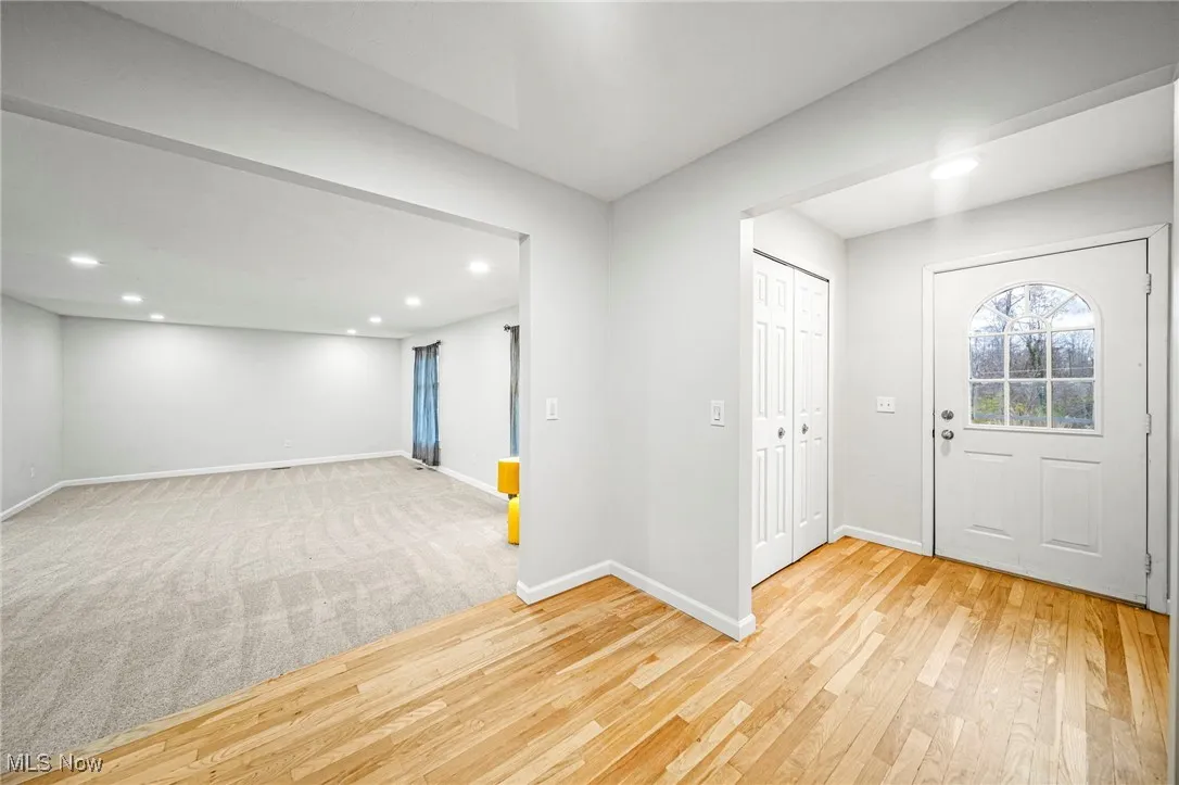Foyer featuring recessed lighting, light wood-style floors, and light carpet