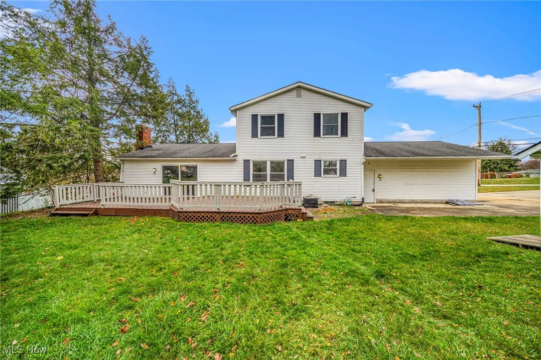 Rear view of property with a wooden deck and a chimney