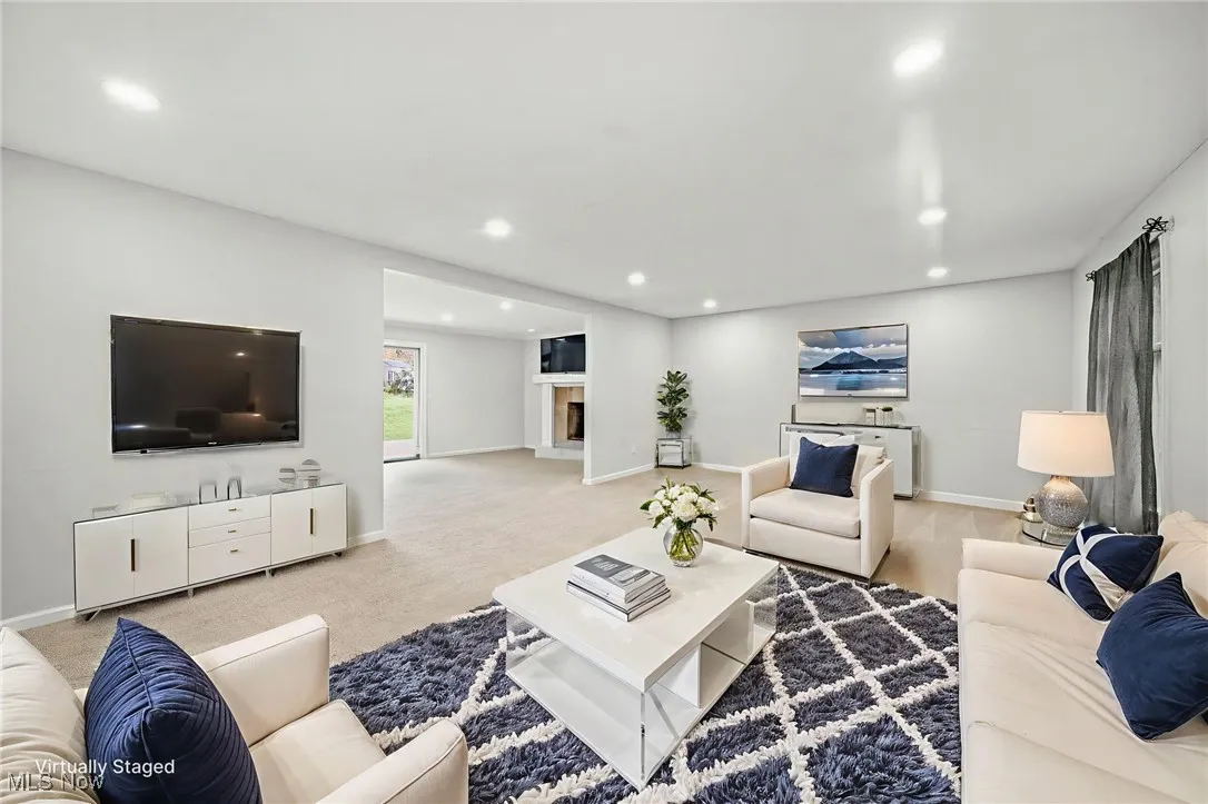 Carpeted living area featuring recessed lighting and a fireplace