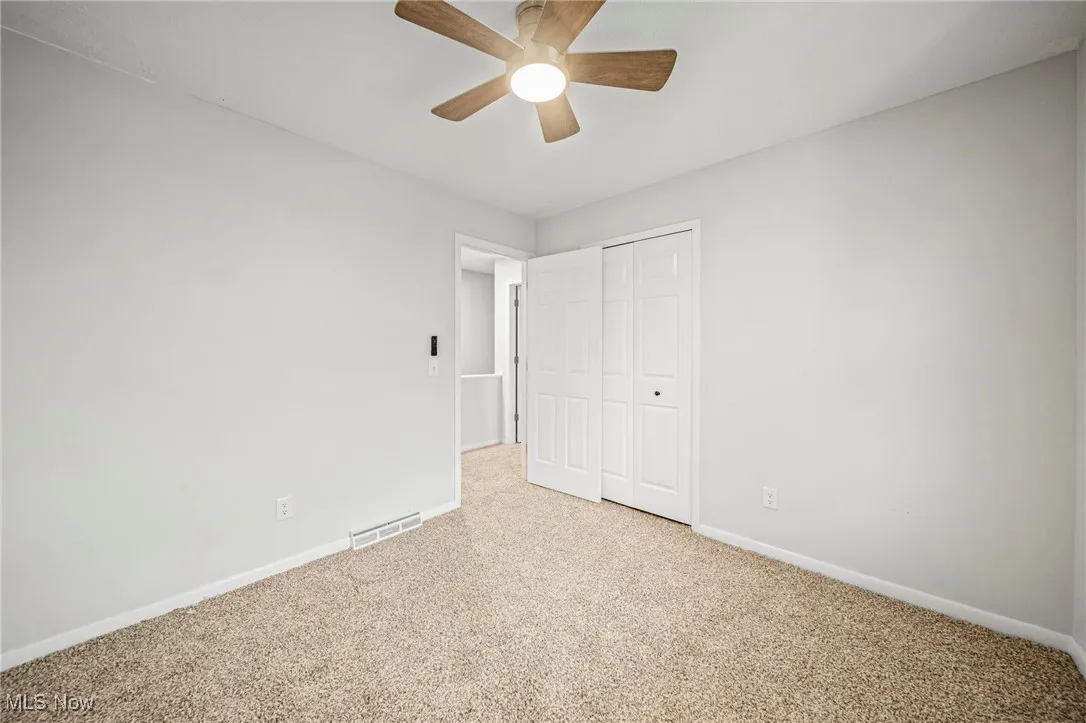 Unfurnished bedroom with carpet flooring, a closet, and a ceiling fan
