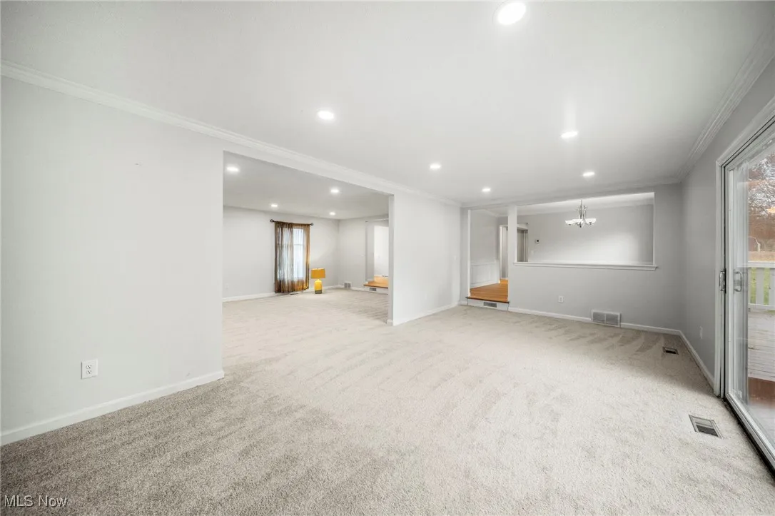 Basement featuring crown molding, recessed lighting, and light carpet