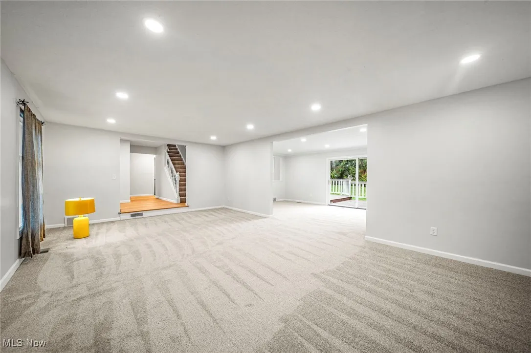 Below grade area with recessed lighting, carpet, and stairs