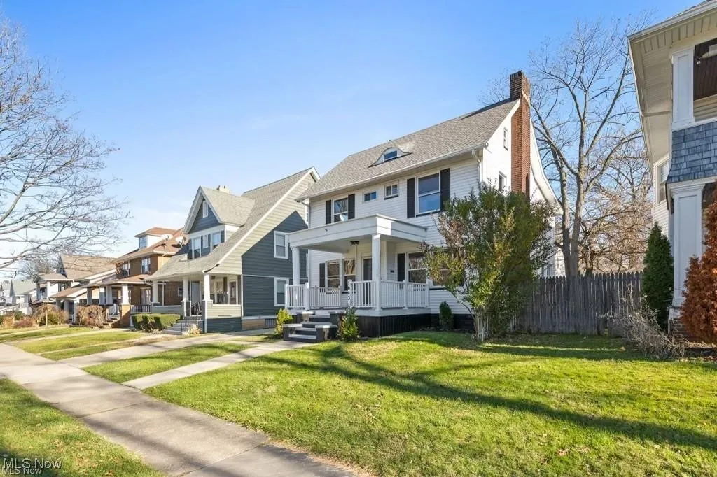 View of front of house with covered porch, a chimney, and a residential view