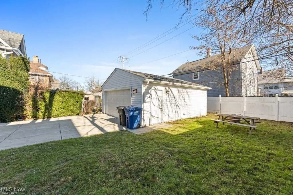 View of side of property with an outdoor structure and a garage