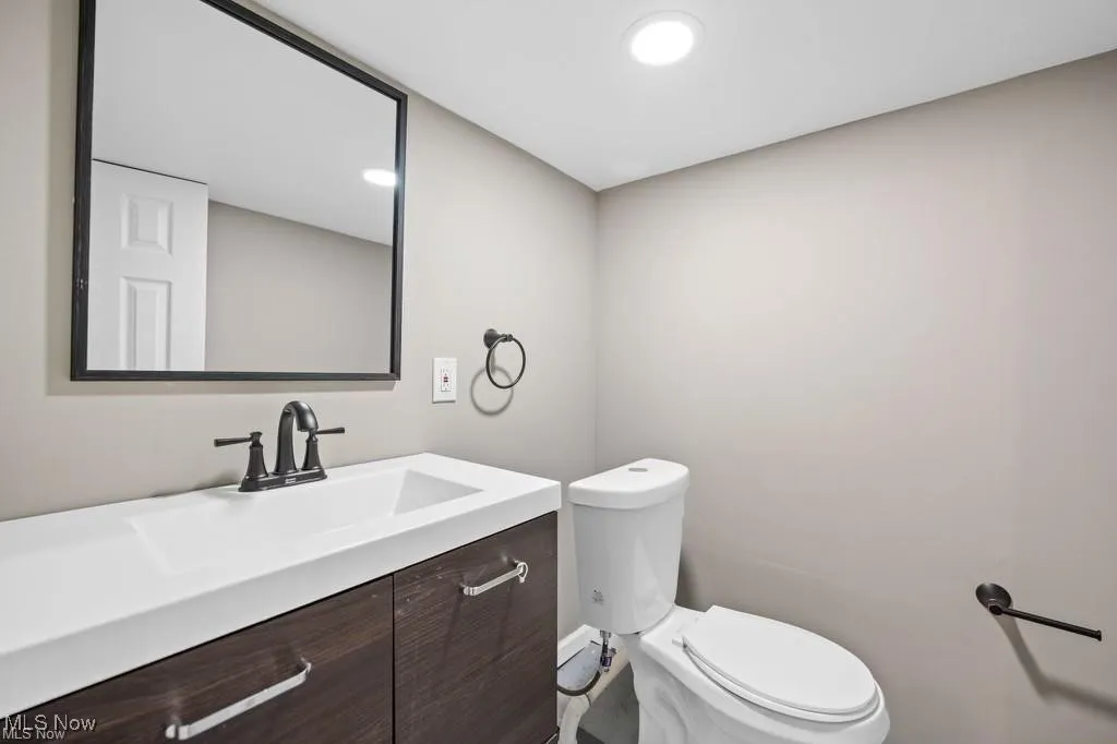 Half bathroom with vanity and recessed lighting