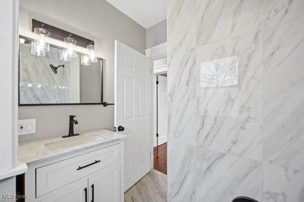 Bathroom featuring vanity and light marble finish flooring