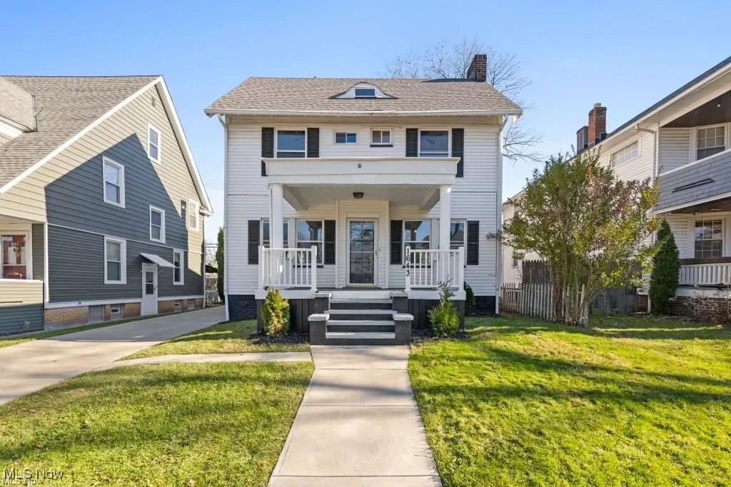 View of front of house featuring a porch, a front lawn, a chimney, and roof with shingles