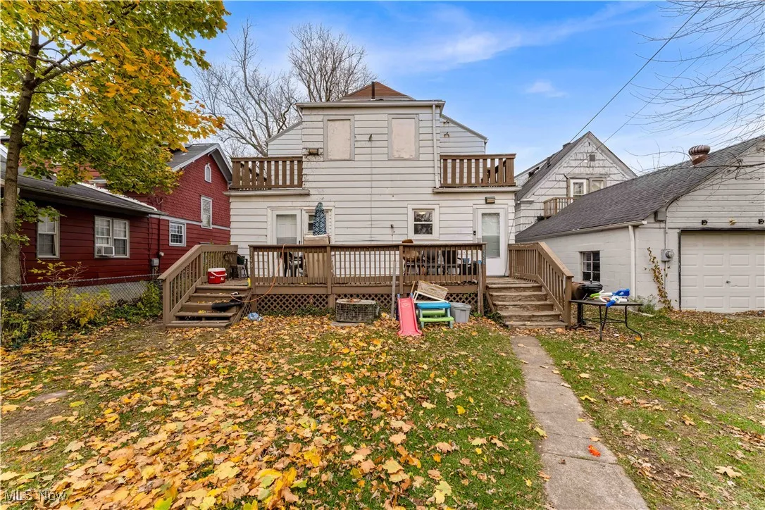 Back of property featuring a deck and a balcony