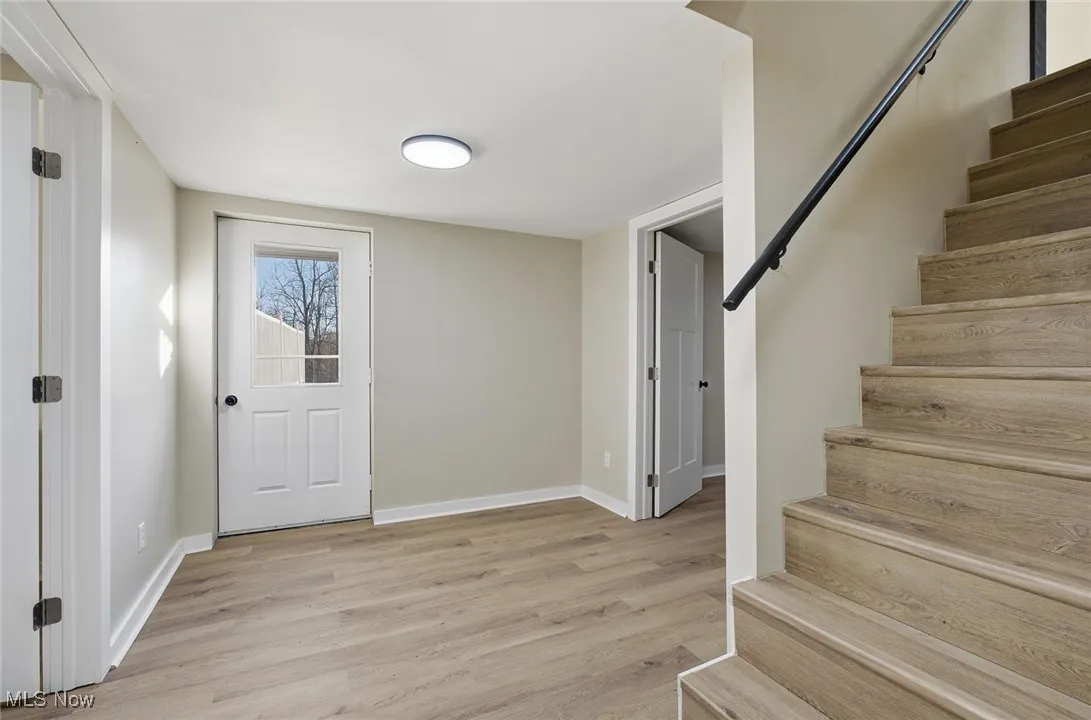 Entrance foyer featuring stairway and light wood finished floors