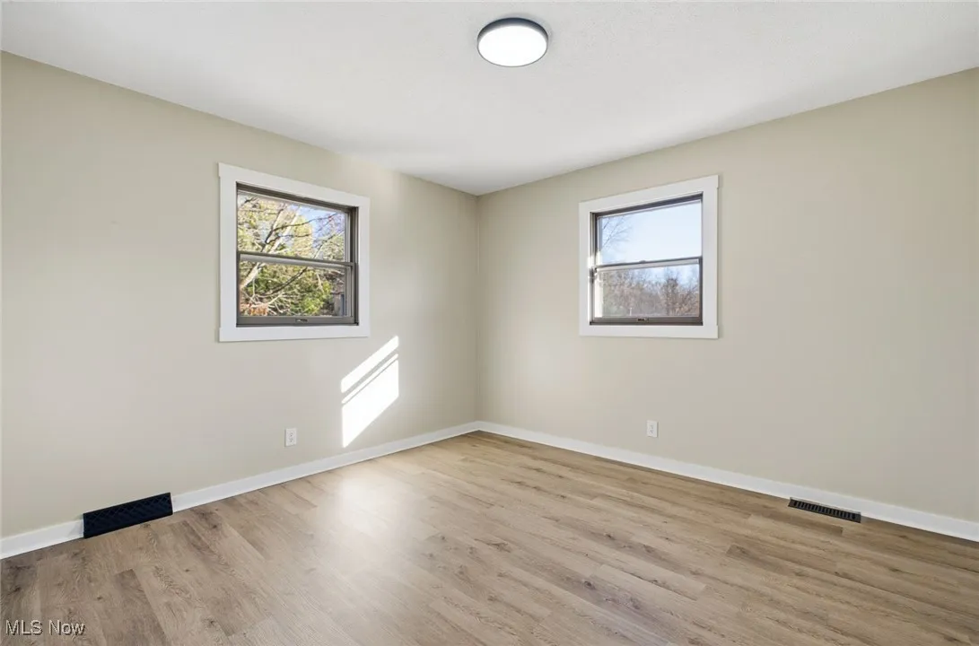 Spare room featuring healthy amount of natural light and light wood-style floors