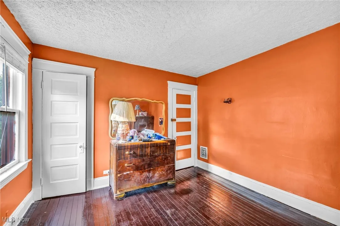 Bedroom with dark wood-type flooring and a textured ceiling