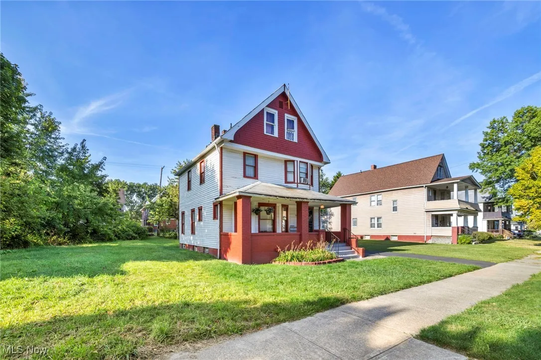 American foursquare style home with a front yard, a porch, and a chimney