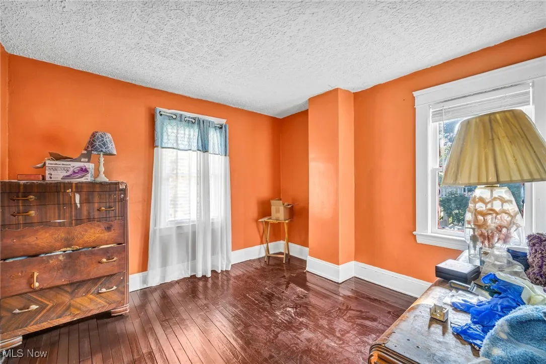 Sitting room with dark wood-type flooring and a textured ceiling