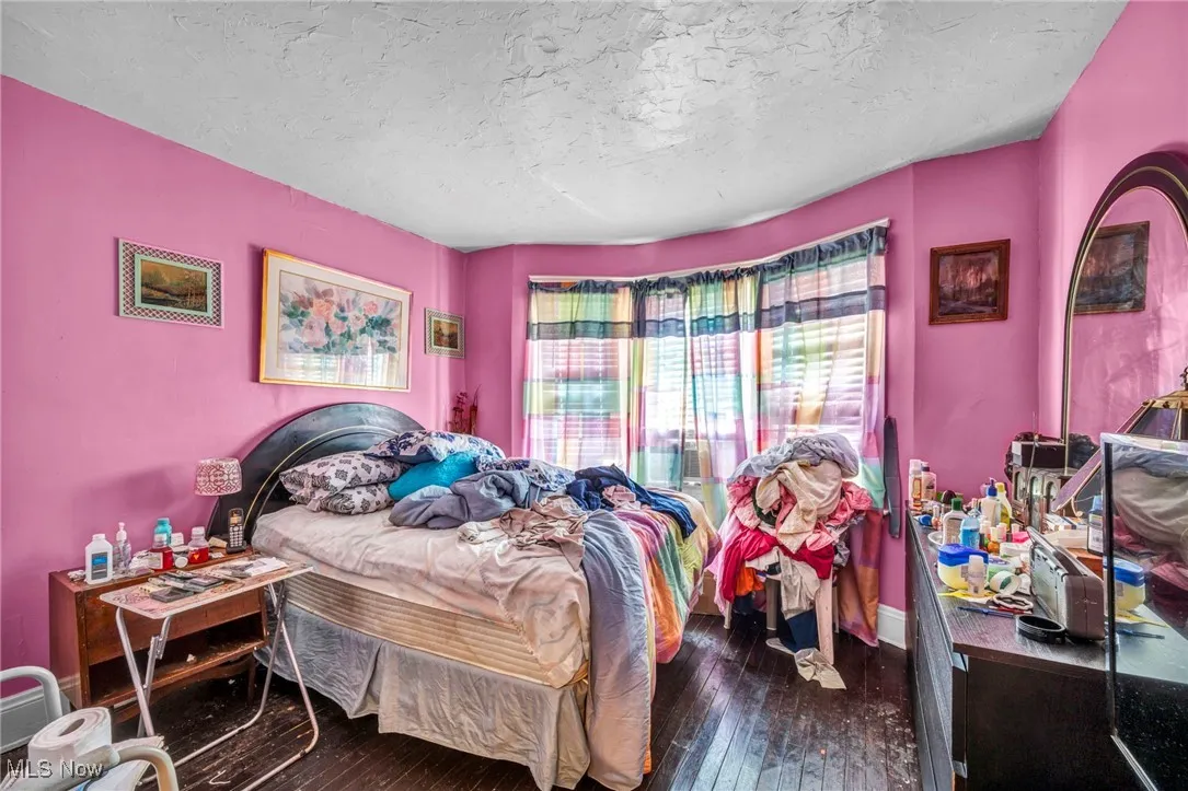 Bedroom with dark wood-style flooring and a textured ceiling