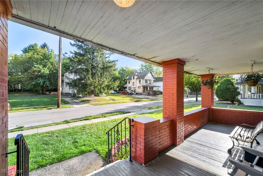 Wooden porch with a residential view and a lawn