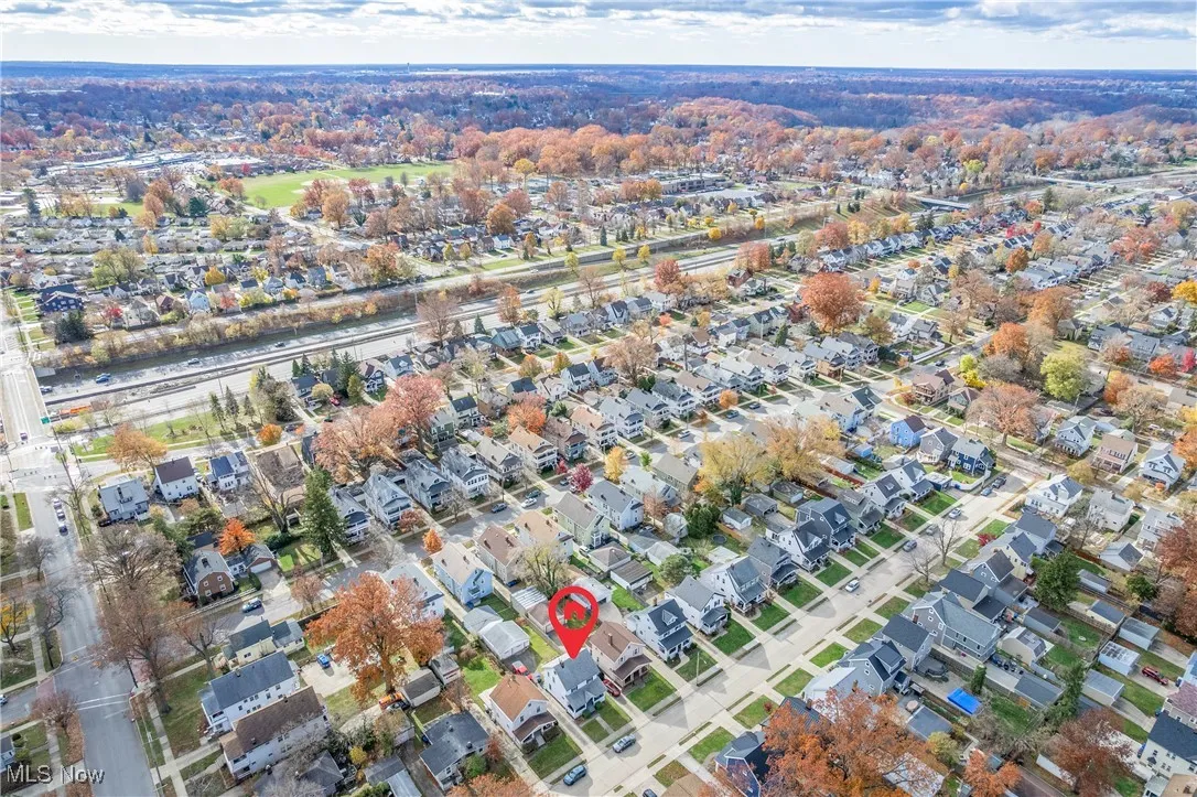Aerial view of property and surrounding area with nearby suburban area