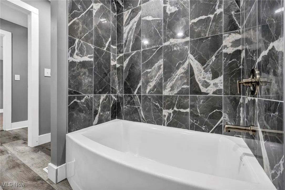 Bathroom featuring a bathtub and wood finished floors