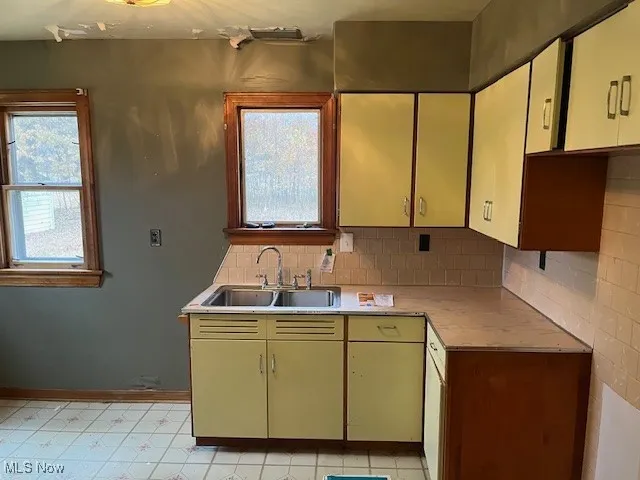 Kitchen featuring light countertops, decorative backsplash, and light flooring