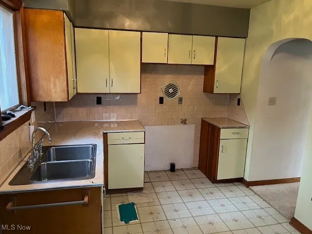 Kitchen with backsplash and arched walkways