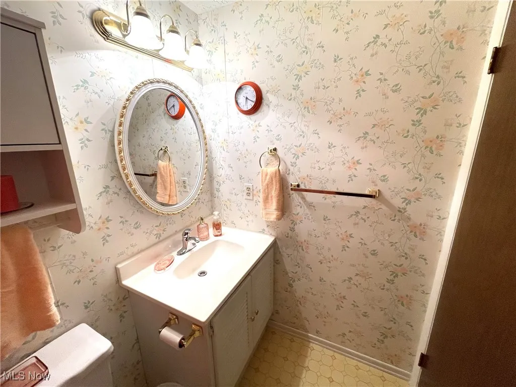 Bathroom featuring vanity and wallpapered walls