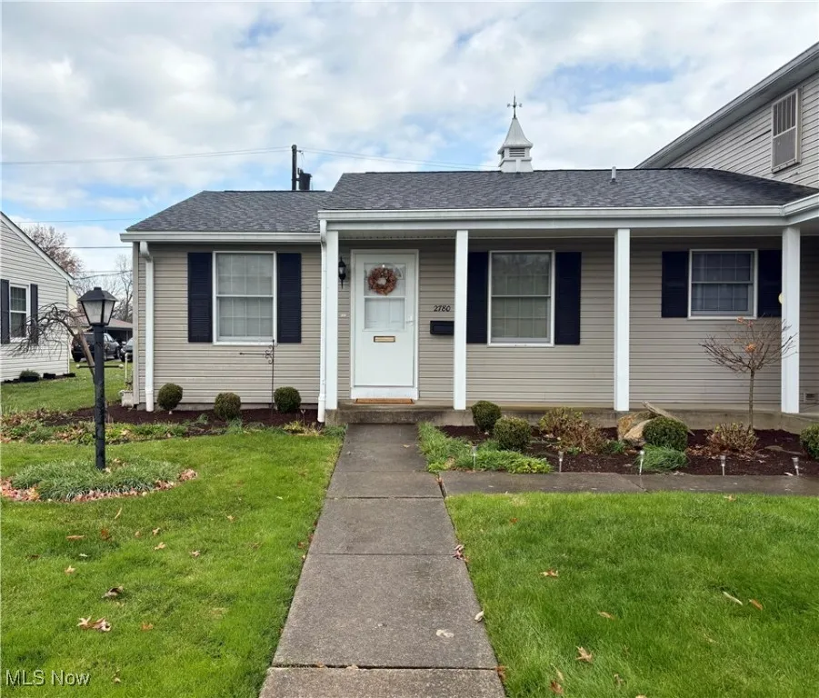 Bungalow-style house with a shingled roof and a front yard