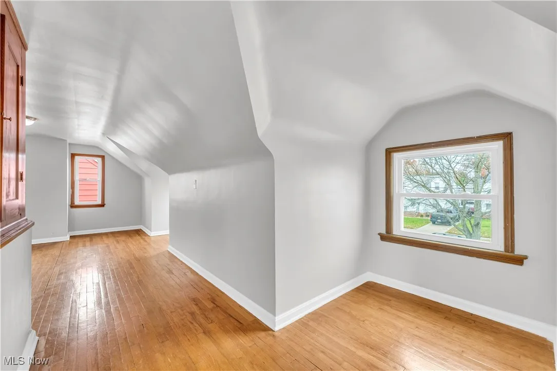 Bonus room with lofted ceiling and light wood finished floors