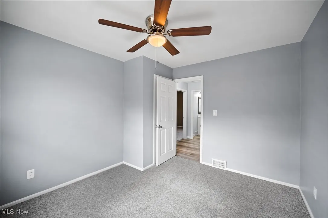 Unfurnished bedroom with carpet flooring and ceiling fan