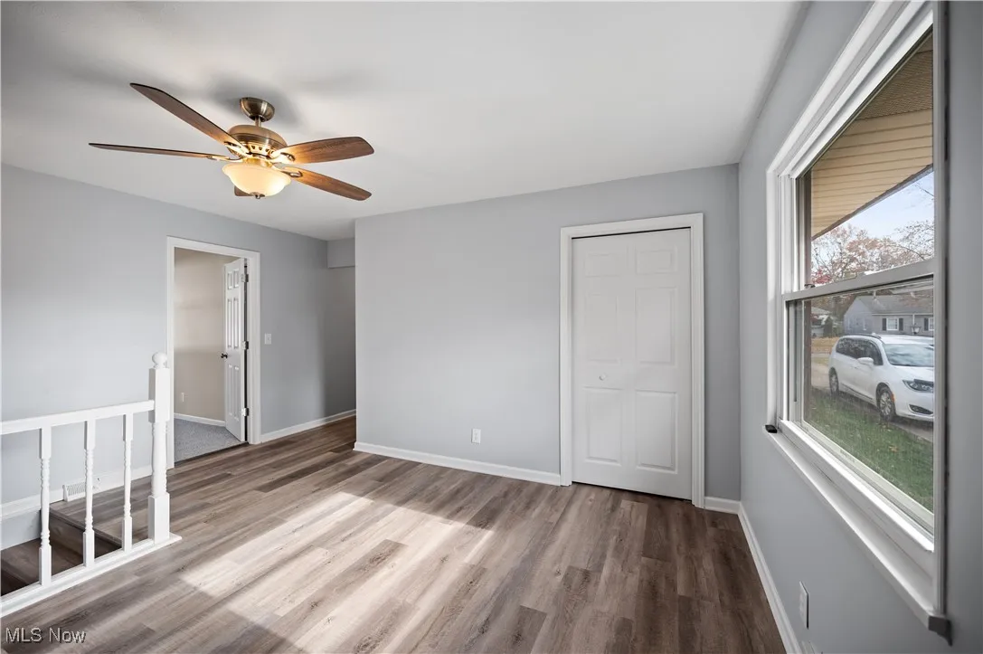 Unfurnished bedroom featuring wood finished floors, a ceiling fan, and a closet