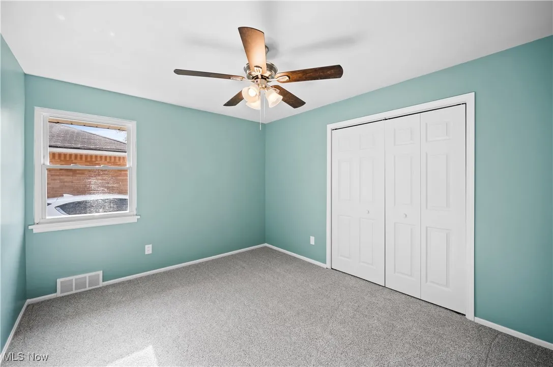 Unfurnished bedroom featuring carpet floors, a closet, and ceiling fan