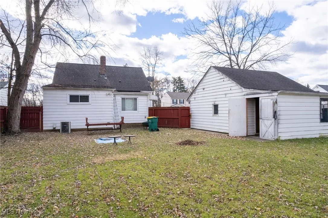 Back of property featuring an outdoor structure and a chimney