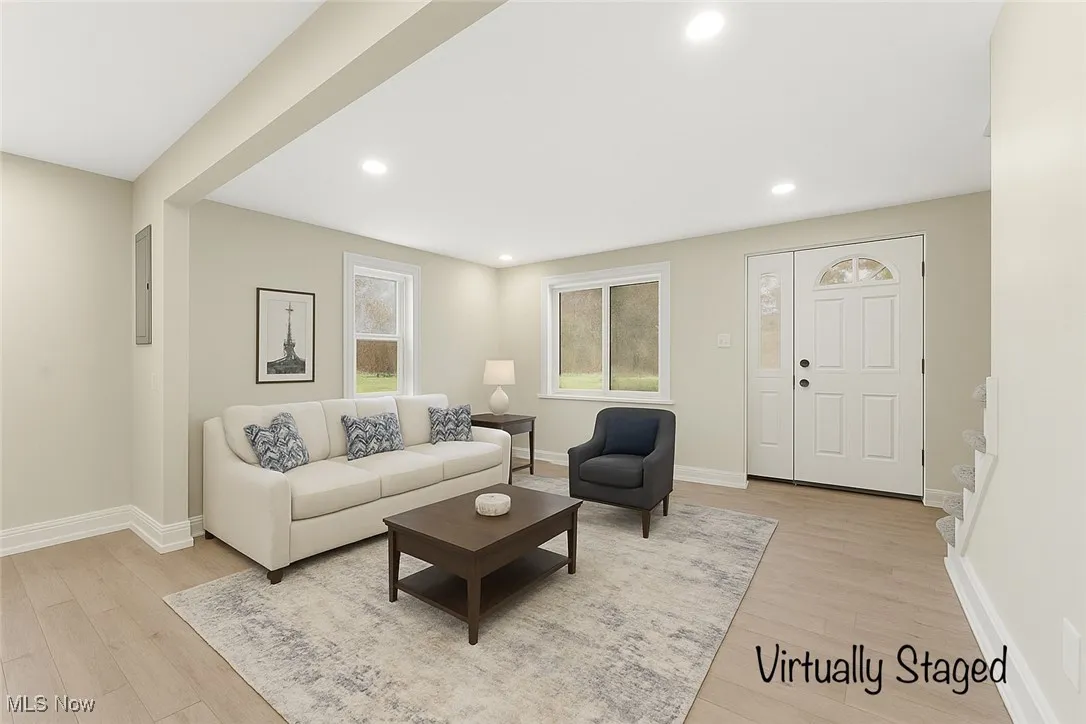 Living area with light wood finished floors and recessed lighting