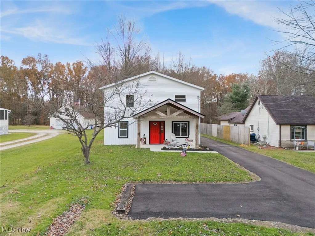 View of front of property featuring asphalt driveway