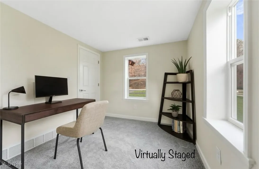 Home office featuring light carpet and baseboards
